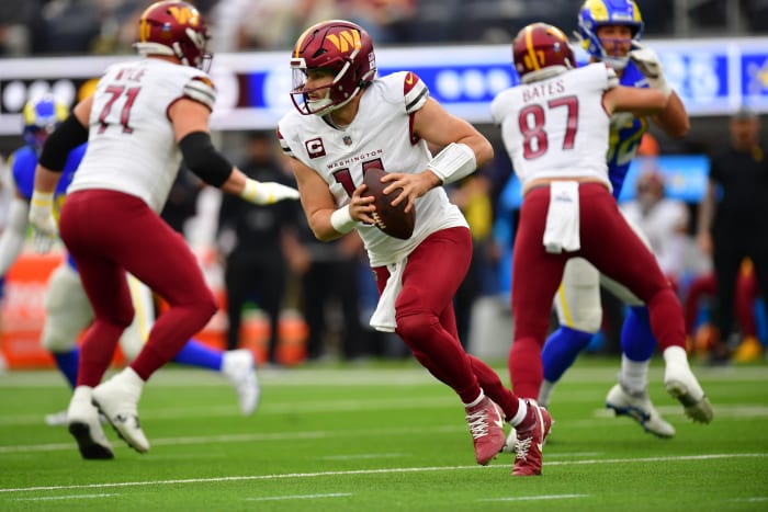 Washington Commanders quarterback Sam Howell (14) moves out to pass against the Los Angeles Rams during the first half at SoFi Stadium.